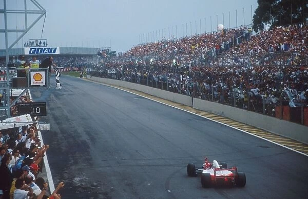 Interlagos, Sao Paulo, Brazil: Ayrton Senna takes the chequered flag for the win