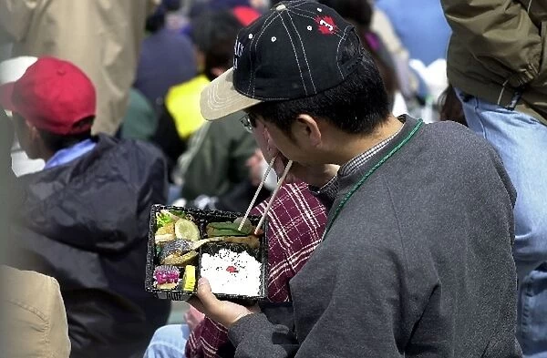 A Japanese fan enjoys his lunch prior to the start of the Bridgestone Potenza 500