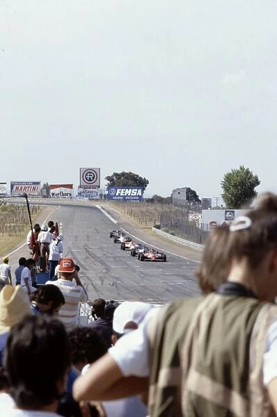 Jarama, Spain. 19th - 21st June: Gilles villeneuve leads a train of cars as the crowd watches. Action