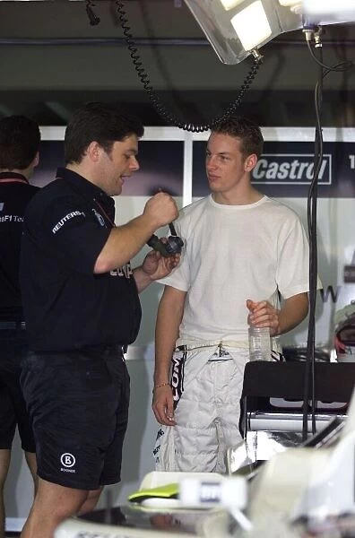 Jenson Button talks with a mechanic