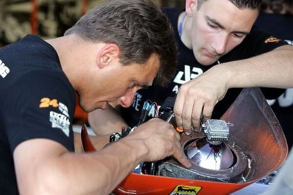Le Mans 24 Hours: A mechanic works on a light housing before the race