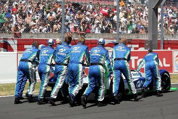 Le Mans 24 Hours: Pescarolo Sport mechanics wave to the fans as they push their car onto the grid