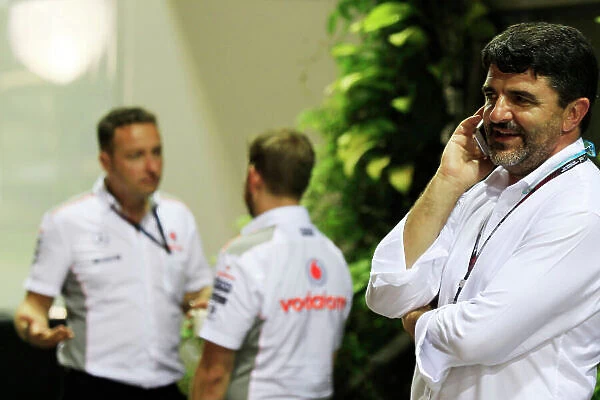 Marina Bay Circuit, Singapore. Friday 20th September 2013. Luis Garcia Abad, Manager of Fernando Alonso talks on a mobile phone near the McLaren team in the paddock. World Copyright: Charles Coates / LAT Photographic. ref: Digital Image _X5J8926