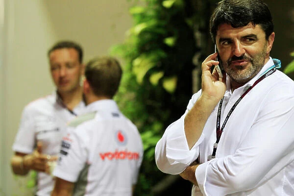 Marina Bay Circuit, Singapore. Friday 20th September 2013. Luis Garcia Abad, Manager of Fernando Alonso talks on a mobile phone near the McLaren team in the paddock. World Copyright: Charles Coates / LAT Photographic. ref: Digital Image _X5J8921