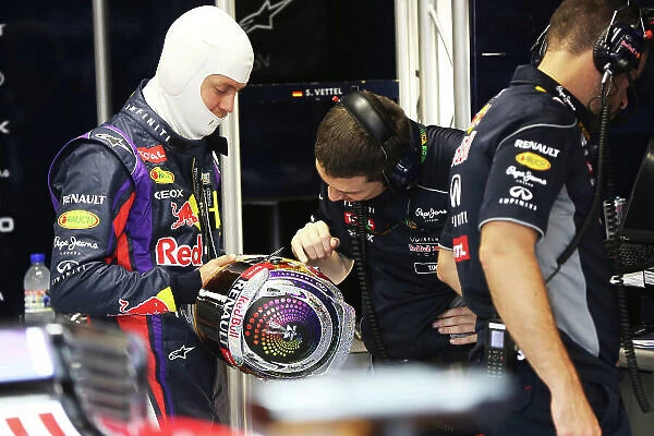 Marina Bay Circuit, Singapore. Friday 20th September 2013. Sebastian Vettel, Red Bull Racing with shows off his latest helmet design to a team member. World Copyright: Andy Hone / LAT Photographic. ref: Digital Image HONZ0919