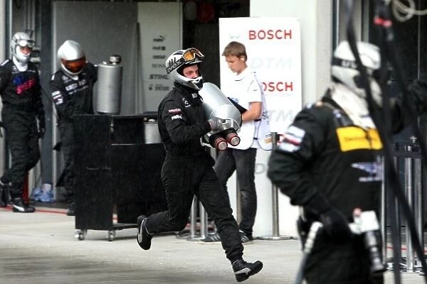 DTM. A Mercedes mechanic picks up the lost fuel can of Bruno Spengler 