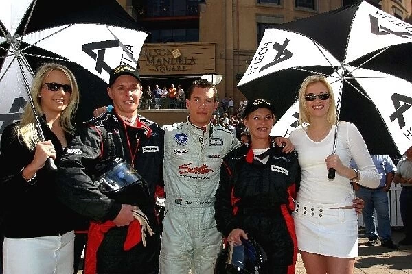 Minardi F1x2: Alan van der Merwe before he hits the street in his Minardi F1X2 with his two lucky passengers and two random umbrella holders