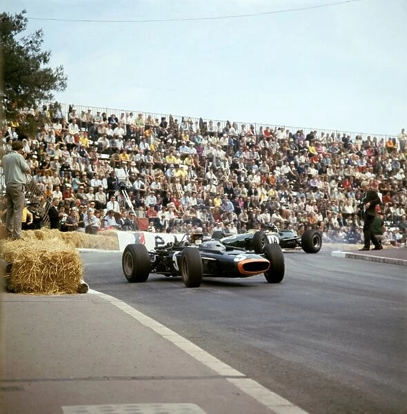 Monte Carlo, Monaco. 7th May: Mike Spence leads Graham Hill. Spence finished 6th, Hill 2nd. Action