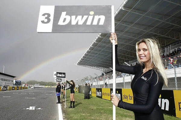 MotoGP grid girls with a rainbow in the background.