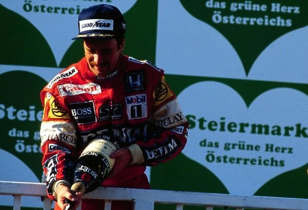 Nigel Mansell celebrates on the podium after winning at the Osterreichring