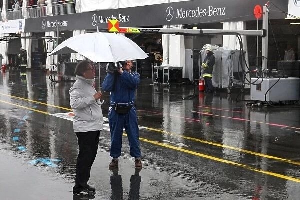 DTM. Norbert Haug (GER), Mercedes-Benz Motorsport Director, shelters from the rain.