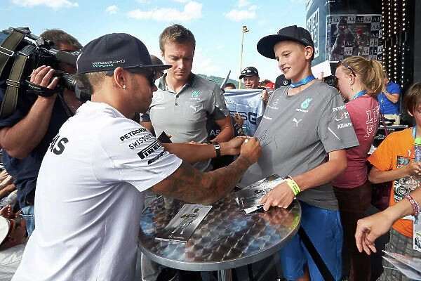 Red Bull Ring, Spielberg, Austria. Saturday 21 June 2014. Lewis Hamilton, Mercedes AMG, signs a fans shirt. World Copyright: Steve Etherington / LAT Photographic. ref: Digital Image SNE25588 copy