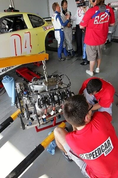 Speedcar Series Testing: Mechanics work on one of the 6.2 litre V8 engines as Johnny Herbert and Heinz-Harald Frenzten are interviewed