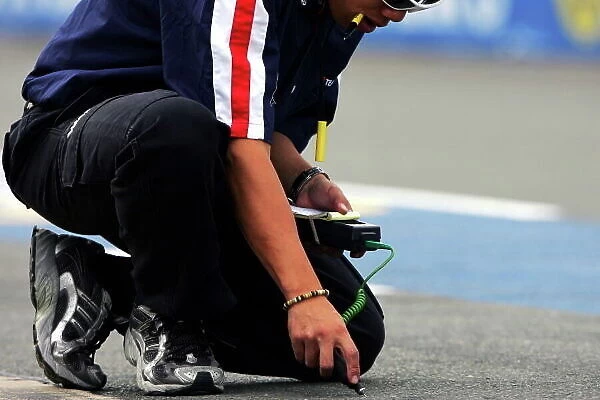 A1GP. Tyre technician checks the track temperature.