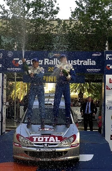 World Rally Championship: Rally winner Marcus Gronholm Peugeot 206 WRC, right, celebrates with his co-driver on the podium. Day three
