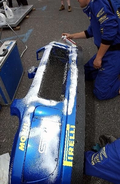 World Rally Championship: A Subaru mechanic cleans the front bumper of an Impreza WRC 03