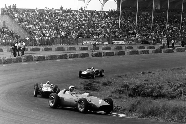 Zandvoort, Holland. 6 June 1960: Phil Hill, Ferrari Dino 246, retired, leads Innes Ireland, Lotus 18-Climax, 2nd position, and Alan Stacey, Lotus 18-Climax
