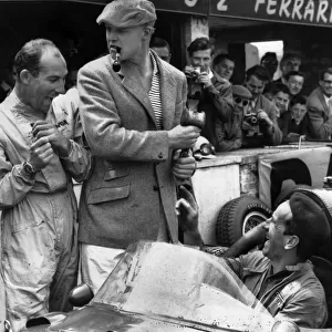 1958 British Grand Prix: Stirling Moss, retired, shares a joke with Mike Hawthorn, 7th position, in the pits with a mechanic, portrait