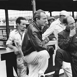 1959 British Grand Prix: Stirling Moss, 2nd position and Harry Schell, 4th position, chat in the pits, portrait