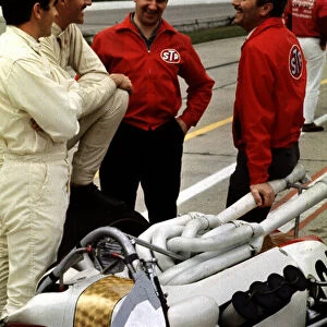 1966 Indianapolis 500. Indianapolis, Indiana, USA. 30th May 1966. Colin Chapman chats with Jackie Stewart and Graham Hill (both Team John Mecom). World Copyright - Dave Friedman / LAT Photographic. Ref: Digital File Only