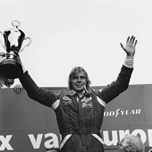 1976 Dutch Grand Prix: James Hunt, 1st position, celebrates on the podium with Clay Regazzoni, 2nd position and Mario Andretti, 3rd position