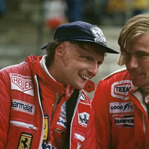 1977 Belgian Grand Prix: Niki Lauda, 2nd position, shares a joke with James Hunt, 7th position, in the pits, portrait