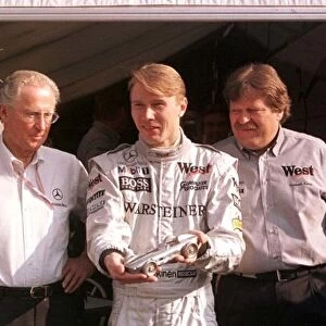 1998 SAN MARINO GP. Mika Hakkinen is presented with a solid silver model of