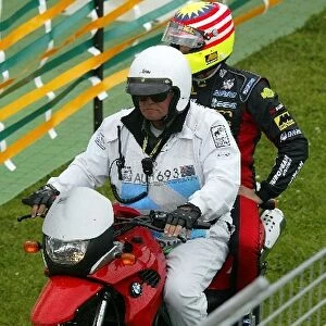 Formula One World Championship: Alex Yoong KL Minardi has a lift back to the pits on a motorbike after stopping out on the track
