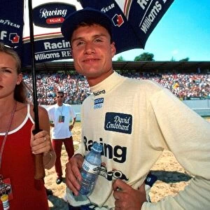Formula One World Championship: David Coulthard Williams with his girlfriend Andrea Murray shelter from the heat prior to the race
