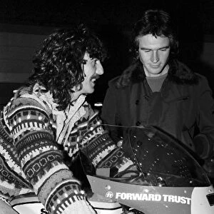 Formula One World Championship: F1 celebrity fan George Harrision Beatles guitarist tries out the Suzuki motorbike of Barry Sheene who was competing