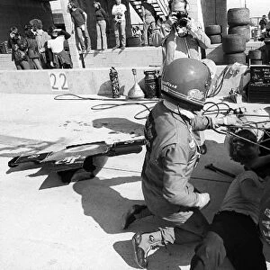 Formula One World Championship: Fifth placed Ronnie Peterson assists with modifications to his Lotus 72E in the pits during practice