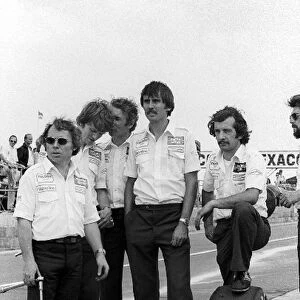 Formula One World Championship: Kenny Szymanski Lotus Tyre Mechanic and Clive Hicks with other Lotus mechanics in the pits