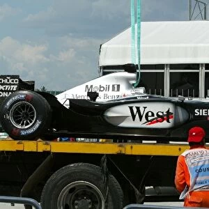 Formula One World Championship: The McLaren MP4 / 17D of David Coulthard is recovered back to the pits after his early retirement from the race