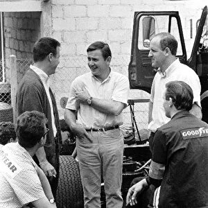 Formula One World Championship: McLaren team owner Bruce McLaren, centre, and team mate Denny Hulme, right, chat with Goodyears Leo Mehl