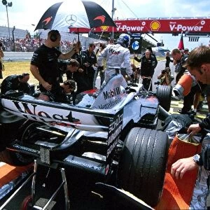 Formula One World Championship: Mechanics work on the McLaren Mercedes MP4-17D of pole sitter Kimi Raikkonen