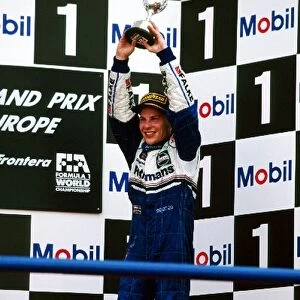 Formula One World Championship: Third placed Jacques Villeneuve Williams celebrates becoming the World Champion on the podium