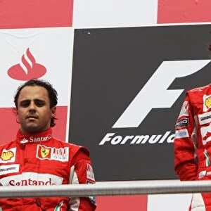 Formula One World Championship: The podium: second placed team mate Felipe Massa Ferrari with race winner Fernando Alonso Ferrari