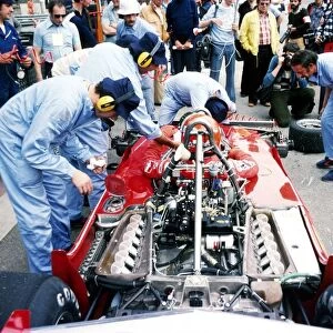 Formula One World Championship: Second placed Niki Lauda sits in his Ferrari 312T2 as mechanics prepare it for action during practice