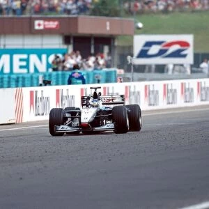 Formula One World Championship: Winner Mika Hakkinen Mclaren MP4-14 crosses the finish line