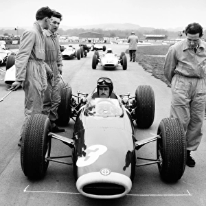 Goodwood, West Sussex, Great Britain. 30 March 1964: Graham Hill, BRM P61 / 2, on the grid. Trevor Taylor, #12 Lotus 24-BRM, lines up behind, portrait