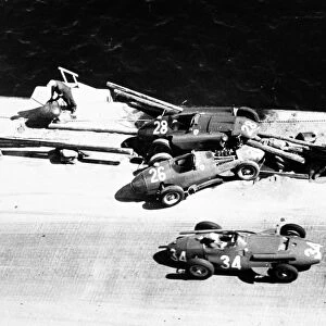 Monte Carlo, Monaco. 19 May 1957: Giorgio Scarlatti, Maserati 250F, retired, passes the crashed cars of Peter Collins, Lancia-Ferrari D50, and Mike Hawthorn
