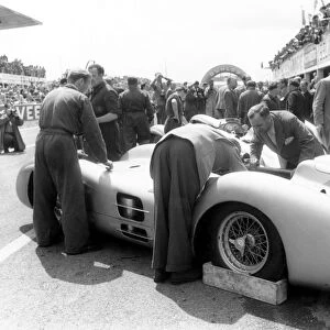 Reims-Gueux, France. 4 July 1954: Mechanics work on the new streamlined Mercedes-Benz W196 in the pits. Juan Manuel Fangio and Karl Kling finished 1st
