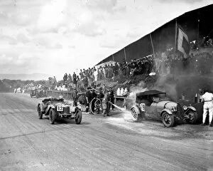 RAC Tourist Trophy Gallery: 1928 RAC Tourist Trophy: Malcolm Campbell on fire in the pit lane. Ian MacDonald passes in his Riley