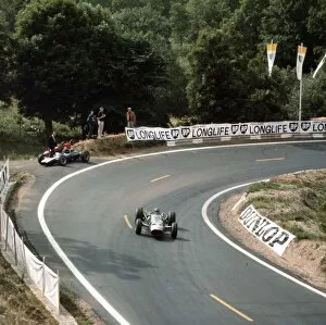 Images Dated 5th February 2010: 1965 French Grand Prix: Graham Hill passes the retired Cooper T77 Climax of Jochen Rindt