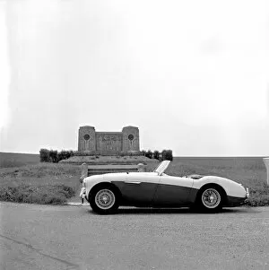 Images Dated 15th June 2005: Austin-Healey 100M in front of memorial for racing drivers Guy Bouriat & Louis
