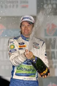 Cardiff Gallery: FIA World Rally Championship: Marcus Gronholm sprays the winners champagne on the podium in Cardiff