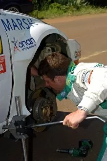 Images Dated 25th June 2005: FIA World Rally Championship: Mark Higgins checks the steering on his Ford Focus WRC 03 before