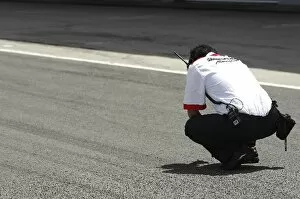 Formula One Testing: Bridgestone engineer checks the track temperature