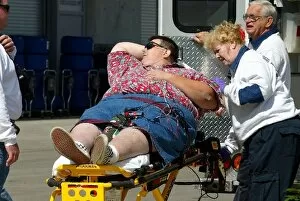 Images Dated 25th September 2003: Formula One World Championship: An American F1 fan is put into an ambulance after being overcome
