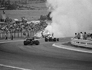 Fire Gallery: Formula One World Championship: Cars stream past the fiery accident involving Mike Hailwood